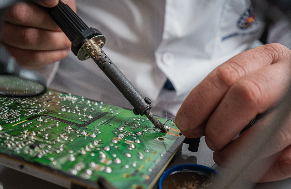 Technician at Inceptial Systems flashing and reprogramming a BIOS chip using a programmer clip